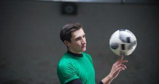 concentrated-soccer-player-training-his-skills-with-ball-spinning-ball-finger