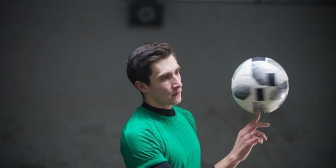 concentrated-soccer-player-training-his-skills-with-ball-spinning-ball-finger