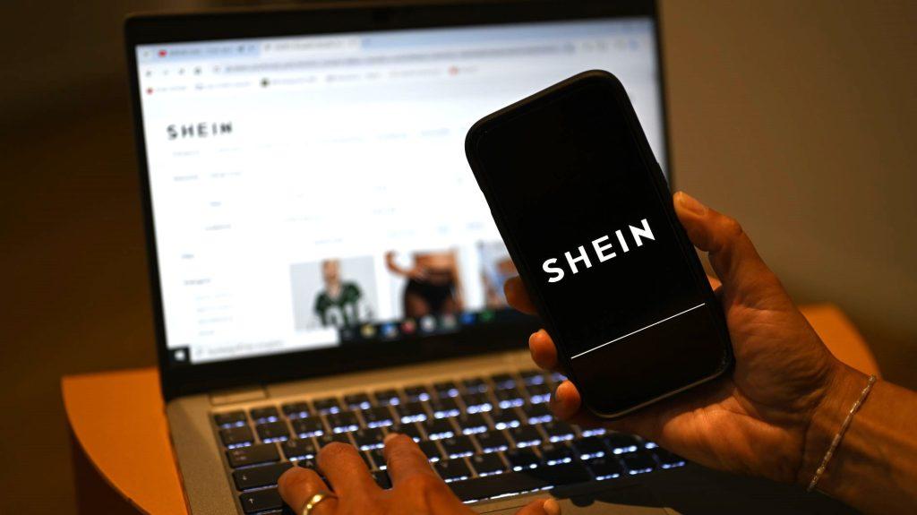Logo Sheina se vidi na pametnom telefonu dok je web stranica kineskog online trgovca otvorena na laptopu / Foto: Monika Skolimowska/dpa