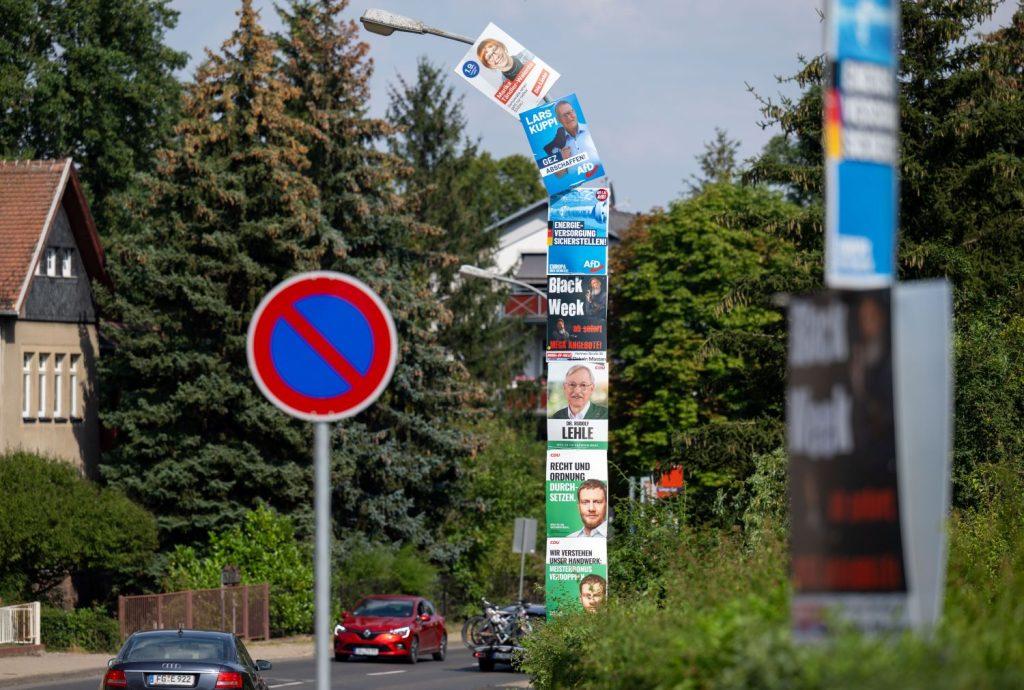 Sechs Wahlplakate von CDU, AfD und Linkspartei sowie ein Werbeplakat umhüllen einen Laternenmast am Stadtrand von Döbeln im ostdeutschen Bundesland Sachsen. Foto: Hendrik Schmidt/dpa